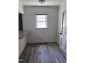 Cozy dining nook with grey wood flooring, bright window, and white door at 808 Belvedere St, Rocky Mount, NC 27803