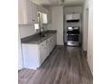 Updated kitchen featuring grey countertop, stainless steel stove, white cabinets and grey wood flooring at 808 Belvedere St, Rocky Mount, NC 27803