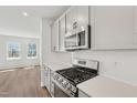 Modern kitchen showcasing quartz countertops, stainless steel appliances, and bright cabinets at 808 Hillfarm Dr, Wake Forest, NC 27587