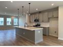 Modern kitchen with an island, stainless steel appliances, and hardwood floors at 808 Hillfarm Dr, Wake Forest, NC 27587