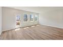 Bright living room with hardwood floors, large windows, and access to a rear deck at 808 Hillfarm Dr, Wake Forest, NC 27587