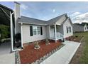 Well-maintained single-story home with a metal roof, attractive landscaping, and a manicured lawn at 1021 Forest Glen Dr, Raleigh, NC 27603