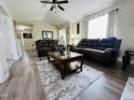 Open-concept living room with wood floors, leather sofas, and a decorative rug at 1021 Forest Glen Dr, Raleigh, NC 27603