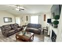 Cozy living room featuring comfortable leather sofas, a ceiling fan, and a decorative fireplace at 1021 Forest Glen Dr, Raleigh, NC 27603