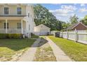 Two-story home boasts a detached garage with driveway and a well-maintained yard at 104 N Green St, Selma, NC 27576