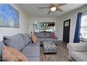 Inviting living room with plush gray sofa, a ceiling fan, and wood-look floors, perfect for relaxation at 114 Short E St, Hillsborough, NC 27278