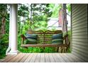 Relaxing porch swing with striped pillows on a covered front porch at 1149 Highway Nc 87, Pittsboro, NC 27312