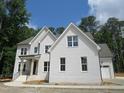 Charming two-story home with white brick, gabled roof, and attached garage at 1444 Old Apex Rd, Cary, NC 27513