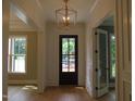 Bright foyer with hardwood floors, stylish lighting, and paneled walls at 1444 Old Apex Rd, Cary, NC 27513