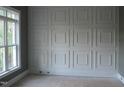 Wall showcasing square paneled wainscoting detail next to a large window at 1444 Old Apex Rd, Cary, NC 27513