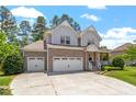 Stunning two-story home with stone accents, a spacious three-car garage, and a beautifully landscaped front yard at 1613 Waddell Ct, Durham, NC 27703