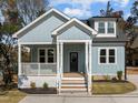 Inviting light blue home with a cozy porch, wooden stairs, and a black front door at 2015 Cheek Rd, Durham, NC 27704