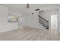 Spacious living room featuring light wood floors, a staircase, and fresh neutral paint at 2015 Cheek Rd, Durham, NC 27704