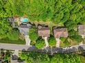 An aerial view of several suburban homes with swimming pools surrounded by lush, mature trees at 208 Bellagio Dr, Apex, NC 27539