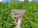 Aerial view of a two-story home with mature trees, a well-manicured lawn, and a two-car garage at 208 Bellagio Dr, Apex, NC 27539