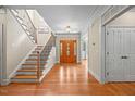 Grand foyer with hardwood floors, staircase with iron railings, and an elegant front door at 208 Bellagio Dr, Apex, NC 27539