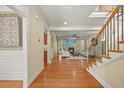 Open living room with hardwood floors, fireplace, large windows, and staircase at 208 Bellagio Dr, Apex, NC 27539