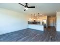 Spacious living area featuring hard surface floors, ceiling fan, and an open kitchen concept at 2205 Gathering Square Ct, Fuquay Varina, NC 27526