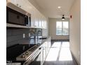 Modern kitchen featuring stainless steel appliances, granite countertops, and ample cabinetry at 2316 Gathering Square Ct, Fuquay Varina, NC 27526