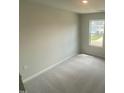 Bright, carpeted bedroom offers natural light through a window with neutral paint and ample space at 247 Paramount Dr # 104, Smithfield, NC 27577