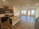Open concept kitchen, with stainless steel appliances, an island sink, and plenty of natural light from the adjacent room at 247 Paramount Dr # 104, Smithfield, NC 27577