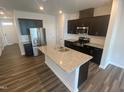 Kitchen showcases stainless steel appliances, a kitchen island sink, dark wooden cabinets and granite countertops at 247 Paramount Dr # 104, Smithfield, NC 27577