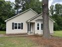 Well-maintained single story home with neutral siding, black shutters, and mature trees at 284 Irvan St, Clayton, NC 27520
