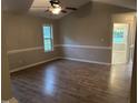Spacious living room features wood-look flooring, a ceiling fan, and access to other rooms at 284 Irvan St, Clayton, NC 27520