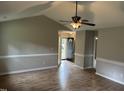 Bright living room with vaulted ceiling, modern paint, wood-look flooring, and decorative chair rail at 284 Irvan St, Clayton, NC 27520