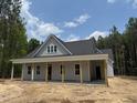 Charming one-story home with a covered front porch and light gray siding, nestled in a wooded lot at 328 Green Pines Estates Dr, Kenly, NC 27542