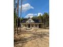 New home featuring a covered porch and surrounded by lush trees at 328 Green Pines Estates Dr, Kenly, NC 27542