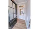 Inviting entryway with paneled wall accents, wood-look flooring, and a glass front door at 355 Beacon Hill Rd # 23, Lillington, NC 27546