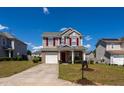 Inviting two-story home showcasing a well-manicured lawn, red shutters, and an attached front garage at 3629 Brittlebank Dr, Raleigh, NC 27610