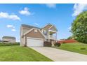 Two story home featuring a two car garage, balcony, and a long driveway at 3832 Stovall Dr, Haw River, NC 27258
