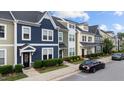 Street view of colorful townhomes with well-manicured lawns and landscaping at 433 Triumph Ln, Wake Forest, NC 27587