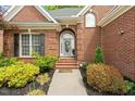 Inviting front entrance of brick home with landscaped garden and arched doorway with decorative wreath at 480 Whitt Ave, Burlington, NC 27215