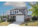 Well-maintained home with two-car garage, complemented by a green lawn and mature landscaping at 49 Pumpkin Hill Rdg, Clayton, NC 27520
