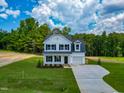 Beautiful two-story home with a well-kept lawn and an attached garage, surrounded by lush trees at 499 Beacon Hill Rd # 30, Lillington, NC 27546