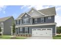 Attractive two-story home featuring gray siding, a prominent garage, and well-placed windows for natural light at 556 Lemon Daisy Ln, Knightdale, NC 27545