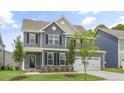 Beautifully designed two-story home with a manicured lawn and gray exterior, showcasing modern living at 556 Lemon Daisy Ln, Knightdale, NC 27545
