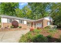 Charming brick home featuring a driveway, garage, and manicured landscaping at 5713 Old Forge Cir, Raleigh, NC 27609