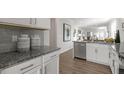 Modern kitchen showcasing granite countertops, gray backsplash, stainless steel appliances, and wood flooring at 600 Sweet Iris Dr, Knightdale, NC 27545