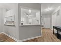 View of foyer with wood floors that opens to the kitchen with white cabinets at 6120 Sunpointe Dr # 102, Raleigh, NC 27606