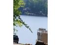 A glimpse of the lake amidst lush trees; hinting at the serene environment surrounding the property at 640 Sagamore Dr, Louisburg, NC 27549