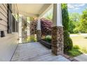 Covered front porch with stone columns and wood decking, perfect for relaxing outdoors at 71 Potted Plant Ct, Clayton, NC 27520