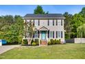 Charming two-story home with gray siding, black shutters, and manicured front yard at 827 Lockesley Ln, Burlington, NC 27217