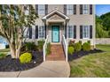 Close-up of a home's entrance featuring a bright blue front door and well-maintained landscaping at 827 Lockesley Ln, Burlington, NC 27217