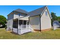 Back exterior of home showcasing a screened porch and light siding, providing a cozy outdoor living space at 1009 Sarazen Dr, Clayton, NC 27527
