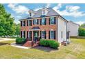 Angle view of a traditional home showcasing brick facade, side siding, and a well-maintained lawn at 1009 Sarazen Dr, Clayton, NC 27527