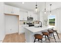 Modern kitchen with white cabinets, stainless steel appliances, a large island, and stylish barstool seating at 103 Mable Ct # 25P, Lillington, NC 27546